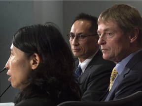 Dr. Gregory Taylor, Canada's chief public health officer of Canada, right, and Dr. Howard Njoo, associate deputy chief, listen to infectious disease expert Dr. Theresa Tam respond to a question during a briefing in Ottawa.
