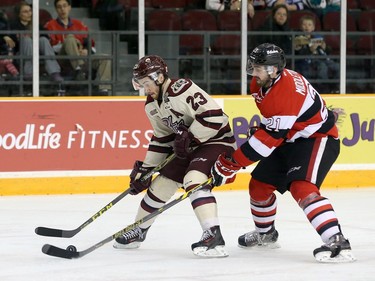 Jacob Middleton #21 of the Ottawa 67's uses his stick to slow down Hunter Garlent #23 of the Peterborough Petes.