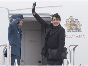 Prime Minister Justin Trudeau waves as he boards his aircraft in Fredericton, N.B. on Tuesday, Jan. 19, 2016, heading to Davos, Switzerland for the World Economic Forum.