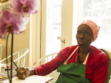 Kehinde Sholola attends day hospice program at May Court for the first time. She hasn't painted before, but thought she'd try her hand at an orchid, a flower she finds encouraging.