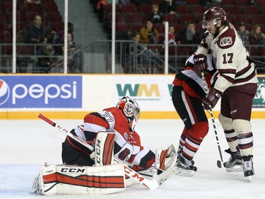 Leo Lazarev #37 of the Ottawa 67's makes a glove save against Greg Betzold #17 of the Peterborough Petes.