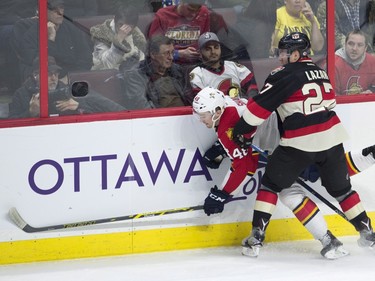 Ottawa Senators right wing Curtis Lazar sends Florida Panthers right wing Logan Shaw into the boards during second period NHL action.