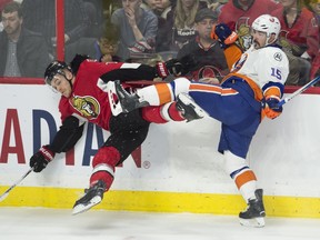 New York Islanders right wing Cal Clutterbuck (15) sends Ottawa Senators defenseman Mark Borowiecki into the boards.