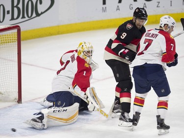 Florida Panthers goalie Roberto Luongo kicks out a shot as he is screened by Ottawa Senators left wing Milan Michalek and defenseman Dmitry Kulikov during first period NHL action.