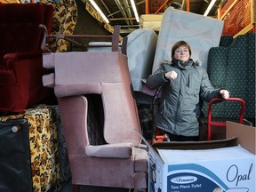 Nathalie Maione stands amidst the floor-to-ceiling furniture in the overflowing warehouse space for Helping With Furniture, a volunteer-run group that collects furnishings, toys, bikes and other donations for those in need.