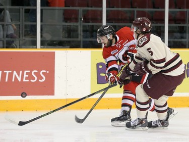 Nathan Todd #81 of the Ottawa 67's chips the puck past Dominik Masin #5 of the Peterborough Petes.