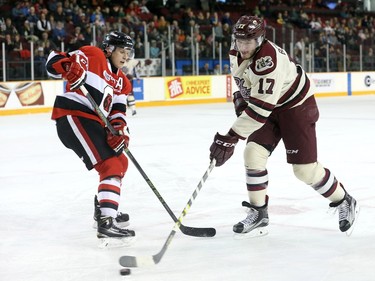 Nevin Guy #24 of the Ottawa 67's defends against a puck carrying Greg Betzold #17 of the Peterborough Petes.