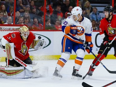 Ottawa Senators goalie Andrew Hammond (30) makes a save as New York Islanders center Anders Lee (27) and Sens Mika Zibanejad (93) look on.