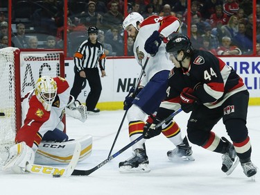 Ottawa Senators' Jean-Gabriel Pageau (44) tires to grab a loose puck in front of Florida Panthers' Roberto Luongo (1) while Erik Gudbranson (44) defends during the first period.