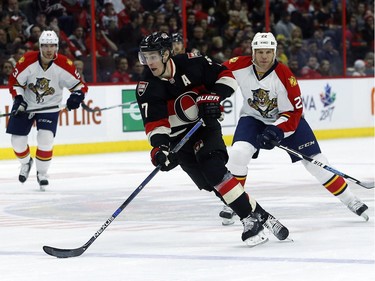 Ottawa Senators' Kyle Turris (7) carries the puck up ice while Florida Panthers' Shawn Thornton (22) looks on during the first period.