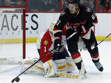 Ottawa Senators' Mark Stone (61) grabs a loose puck in front of Florida Panthers' goalie, Roberto Luongo (1) during the first period.