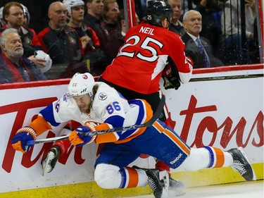 Ottawa Senators right wing Chris Neil (25) checks New York Islanders left wing Nikolay Kulemin (86).