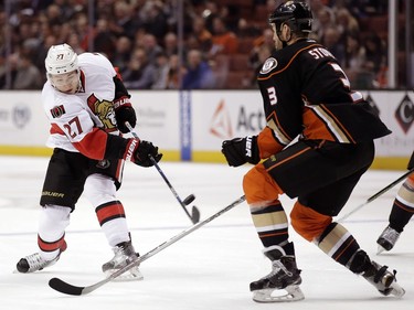 Ottawa Senators right wing Curtis Lazar, left, shoots past Anaheim Ducks defenseman Clayton Stoner during the first period of an NHL hockey game in Anaheim, Calif., Wednesday, Jan. 13, 2016.