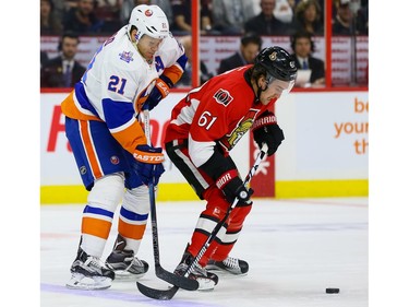 Ottawa Senators right wing Mark Stone (61) battles with New York Islanders right wing Kyle Okposo (21).