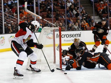 ANAHEIM, CA - JANUARY 13:  Zack Smith #15 of the Ottawa Senators and Hampus Lindholm #47, Clayton Stoner #3 and Frederik Andersen #31 of the Anaheim Ducks battle for a loose puck in front of the net during the second period of a game at Honda Center on January 13, 2016 in Anaheim, California.