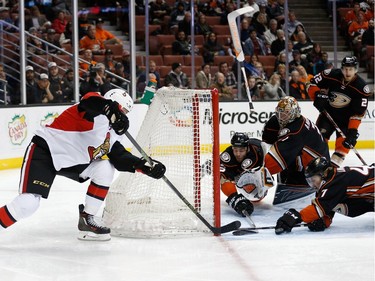 ANAHEIM, CA - JANUARY 13:  Zack Smith #15 of the Ottawa Senators and Hampus Lindholm #47, Clayton Stoner #3 and Frederik Andersen #31 of the Anaheim Ducks battle for a loose puck in front of the net during the second period of a game at Honda Center on January 13, 2016 in Anaheim, California.