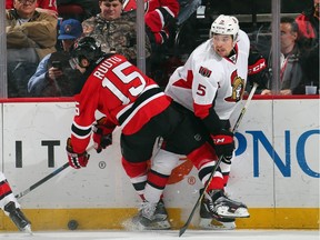 Tuomo Ruutu #15 of the New Jersey Devils gets tangled up with Cody Ceci #5 of the Ottawa Senators during the second period.