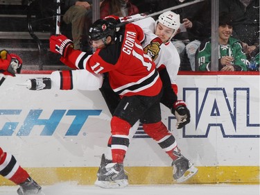 Stephen Gionta #11 of the New Jersey Devils steps into Mark Borowiecki #74 of the Ottawa Senators during the first period.