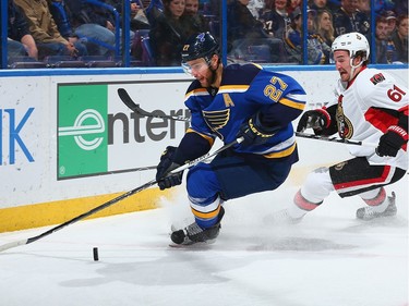 Alex Pietrangelo #27 of the St. Louis Blues and Mark Stone #61 of the Ottawa Senators chase down the puck.