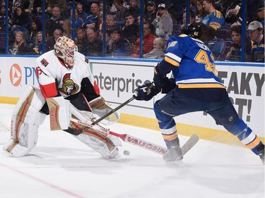 Andrew Hammond #30 of the Ottawa Senators attempts to clear the puck against the St. Louis Blues.