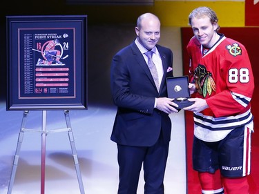 Chicago Blackhawks General Manager Stan Bowman presents a gold puck to Patrick Kane (88) on the night the Chicago Blackhawks celebrated his 24 game point streak earlier in the season before an NHL hockey game against the Ottawa Senators, Sunday, Jan. 3, 2016, in Chicago.