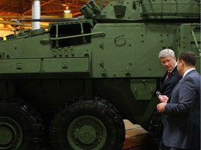 Prime Minister Stephen Harper tours the General Dynamics Land Systems - Canada plant, next to a LAV 6.0 (Light Armoured Vehicle) being built for Canada, at the facility in London, Ont., Friday, May 2, 2014.