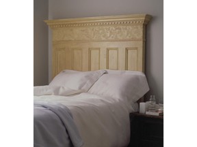 An old door is transformed into an elegant headboard with paint and decorative trim.