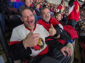 Serge Pomainville, left, and OC Transpo driver Tim Wilkinson enjoy the game as the Ottawa Senators take on the New Jersey Devils in NHL action Wednesday night.