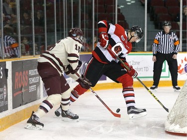 Stepan Falkovsky #51 of the Ottawa 67's tries to get the puck from Steven Lorentz #16 of the Peterborough Petes.