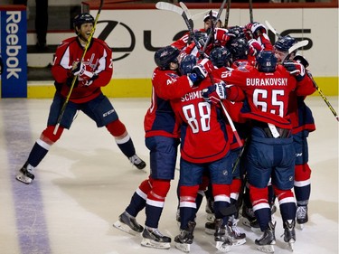 The Washington Capitals swarm the ice around left wing Alex Ovechkin, of Russia, in celebration after Ovechkin scored his 500th career NHL goal during the second period of a hockey game against the Ottawa Senators in Washington, D.C., Sunday, Jan. 10, 2016.