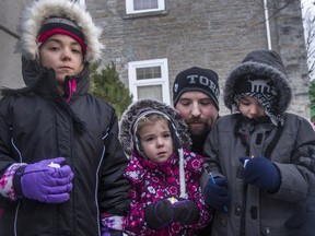 Thomas Harris comforts his three children, Dakota, 8, Harlow, 4, and Leland, 6, at a candlelight vigil held Sunday in Smiths Falls in honour of the children's mother and Thomas's wife, Elizabeth, who died in a car collision on Wednesday.