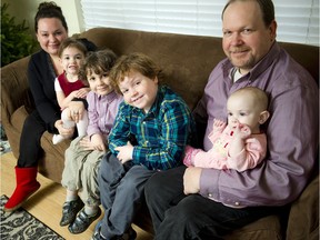 William Greer, seated beside his father, was diagnosed with an inoperable tumour in his brain stem when he was five years old but recently got to ring the end-of-treatment bell at CHEO. From left, are his mother, Lindsay Pritchard, Gwendolyn Greer, 3, Aidan Greer, 6, William, 8, Patrick Greer and 11-month-old Rosie Greer.