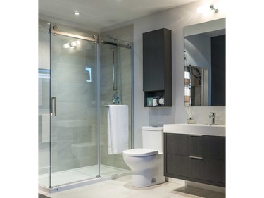 A bathroom vignette at the sales centre highlights the the sleek glass shower enclosure with custom roller-track sliding mechanism and floating vanity.