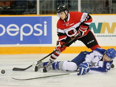 67s player Chase Campbell and Wolves player Reagan O'Grady battle for the puck in the first period.