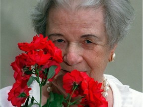 Felicitas Svejda holds a Champlain rose, one of her hardy Canadian Explorer series.