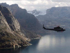 This file photo shows a Canadian military Griffon helicopter flying along the shoreline of Baffin Island. Some are arguing that the Port of Churchill, Manitoba should be acquired by the Canadian government since it is a strategic asset for Arctic operations.