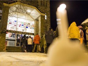 A candle burns outside Almonte Old Town Hall where about a hundred people showed up to remember Bernard Cameron, a retired high school teacher and town councillor, who was shot and killed Thursday by his daughter's estranged common-law partner.
