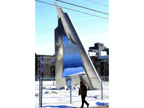 A man is dwarfed by the new iceberg sculpture on the lawn of the Museum of Nature.