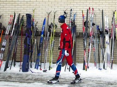 A skier walks by a wall lined with skis outside  Ecole secondaire Mont-Bleu where the Gatineau Loppet took place Saturday February 27, 2016.