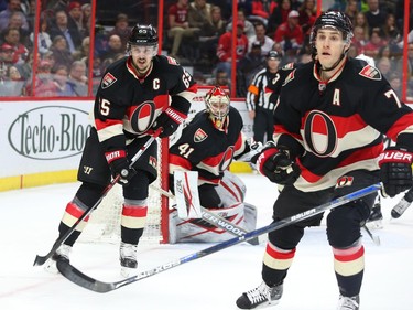 A tired Erik Karlsson, left, Craig Anderson and Kyle Turris, right, of the Ottawa Senators defence against the Carolina Hurricanes during second period NHL action.
