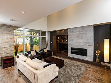 The fireplace with its stone-like porcelain tile surround and rift-cut walnut cabinetry provides a focal point in the main living area. “Walnut is a recurring theme throughout the house. It’s one of those veneers that screams modern and contemporary,” says Balca. The stained maple hearth is a subtle contrast with the walnut.