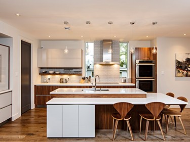 In the kitchen, “storage and ergonomics were the big thing,” says Julinda Balca of Kitchens by Design, who designed the home’s cabinetry. The charcoal door to the left of the counter leads to a walk-in pantry and the unit to the pantry’s left conceals the coffee maker and other items. The breakfast bar is at table height to accommodate children and adults alike.