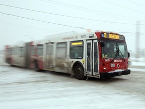 An OC Transpo bus makes its way along Scott St. towards downtown Ottawa during a winter storm Tuesday February 16, 2016.