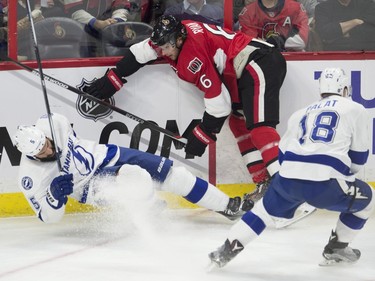 Ottawa Senators right wing Bobby Ryan (6) collides with Tampa Bay Lightning defenceman Jason Garrison (5) along the boards as left wing Ondrej Palat looks on during first period NHL action.