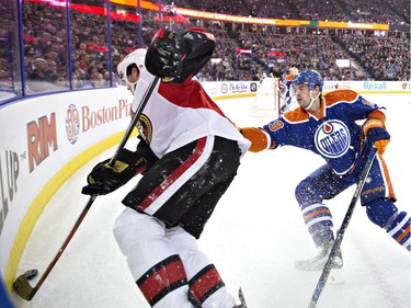 Ottawa Senators ' Bobby Ryan (6) battles in the corner with Edmonton Oilers' Justin Schultz (19) during first period NHL action.