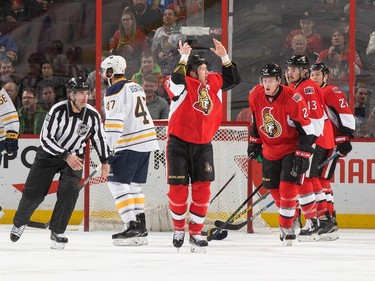 Chris Neil #25 of the Ottawa Senators raises his arms to pump up the crowd after a fight.