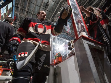 Dion Phaneuf #2 of the Ottawa Senators high-fives a young fan as he leaves the ice after warming up.