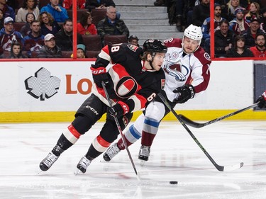 Mike Hoffman #68 of the Ottawa Senators skates with the puck past John Mitchell #7 of the Colorado Avalanche.