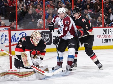 Andrew Hammond #30 of the Ottawa Senators makes a save as team mate Dion Phaneuf #2 defends against Matt Duchene #9 of the Colorado Avalanche.