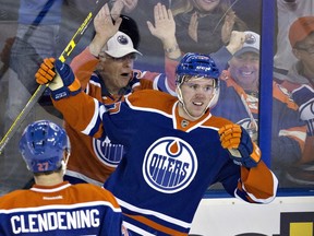 Edmonton Oilers' Connor McDavid (97) and Adam Clendening (27) celebrate McDavid's goal against the Columbus Blue Jackets during second period NHL action in Edmonton, Alta., on Tuesday February 2, 2016.